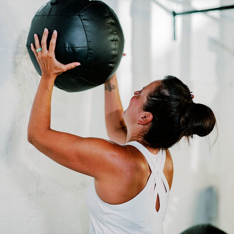 Woman training with wall ball with a Personal Trainer in Huntsville AL